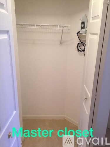 A white closet with a door and a hanger rod.