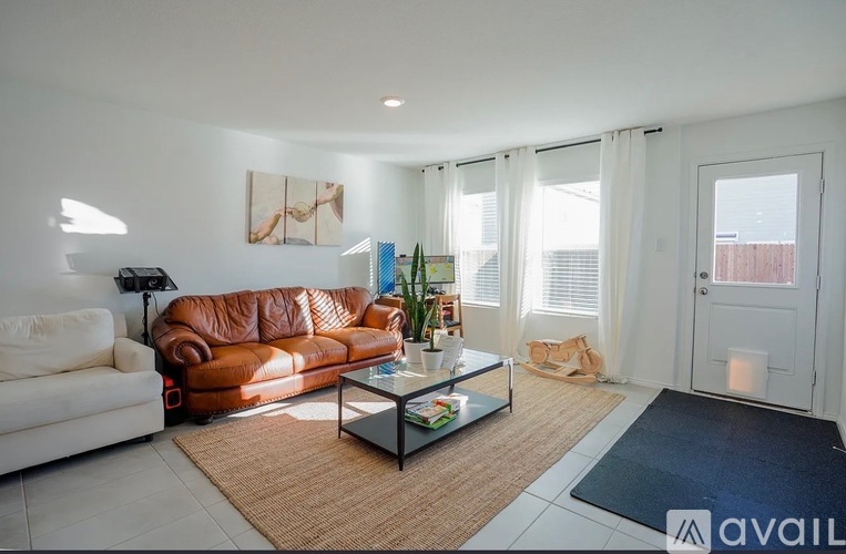 A living room with a brown leather couch and a glass coffee table.