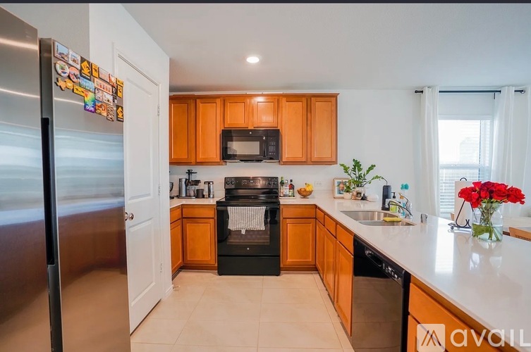 A kitchen with wooden cabinets and a stainless steel refrigerator.