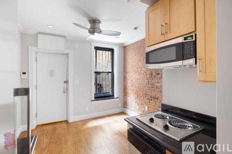A kitchen with a brick wall and a stove top oven.