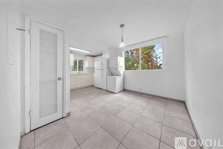 A spacious, empty room with white walls and a tiled floor.