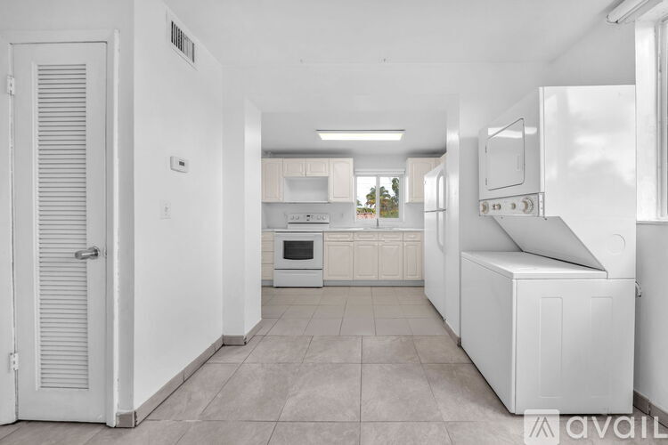 A kitchen with white appliances and cabinets.
