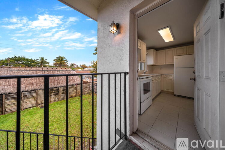 A balcony with a view of a grassy area and trees.