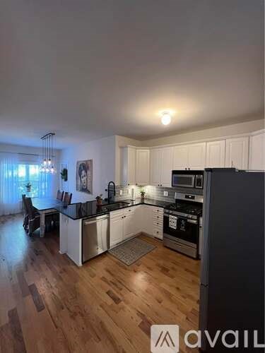 A kitchen with wooden floors and white cabinets.