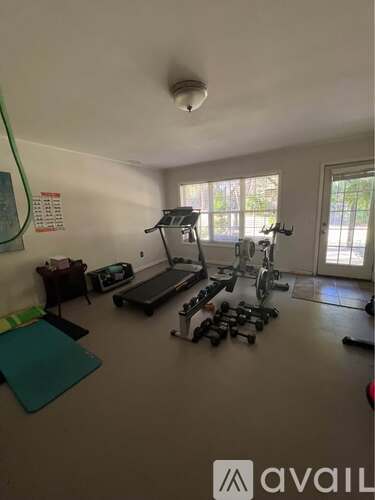 A home gym with a variety of equipment including a treadmill, elliptical trainer, and weights.