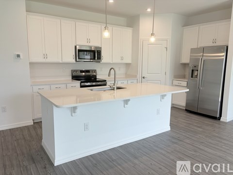 A kitchen with white cabinets and a white island.