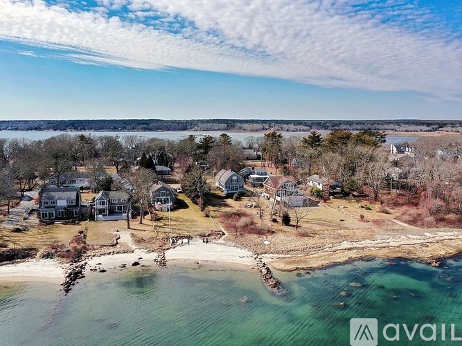 A bird's eye view of a beachfront property with houses and a body of water.