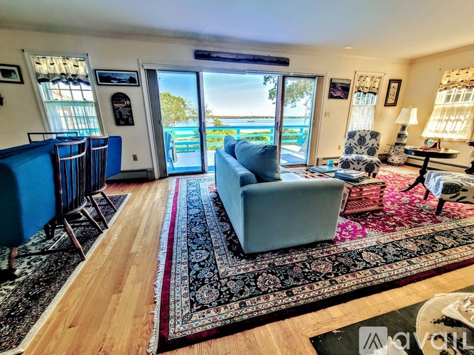 A living room with a view of the ocean through the sliding glass doors.