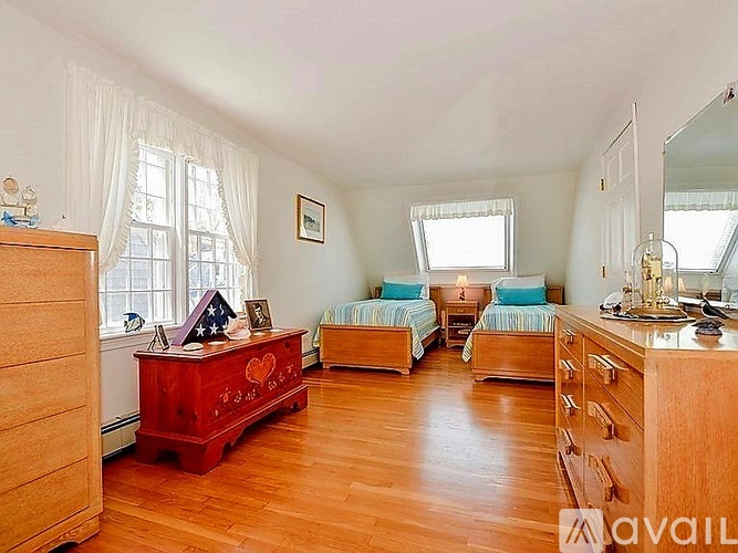 A bedroom with two beds and a dresser.