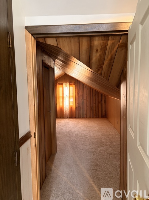 A wooden hallway with a light at the end.