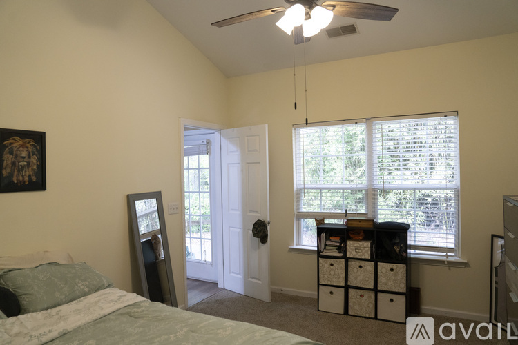 A bedroom with a bed, dresser, and window with blinds.