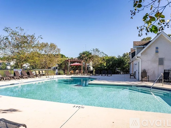 A pool with a house and trees in the background.
