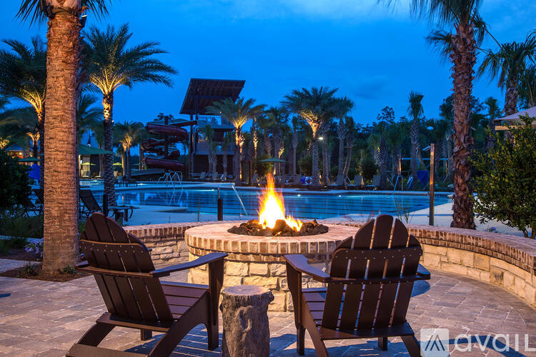A fire pit sits between two chairs on a patio.