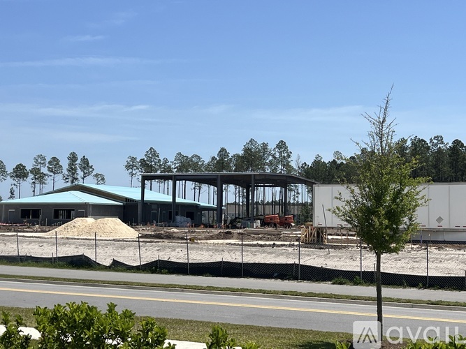 A construction site with a building under construction surrounded by a fence.