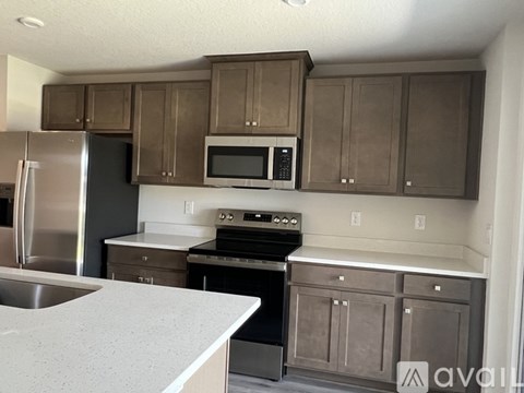 A kitchen with brown cabinets and stainless steel appliances.