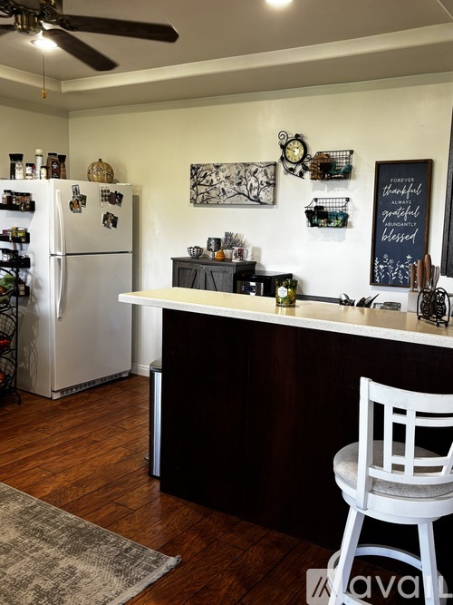 A kitchen with a white refrigerator and a black counter.