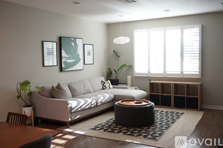 A living room with a grey sofa, a round table, and a rug.