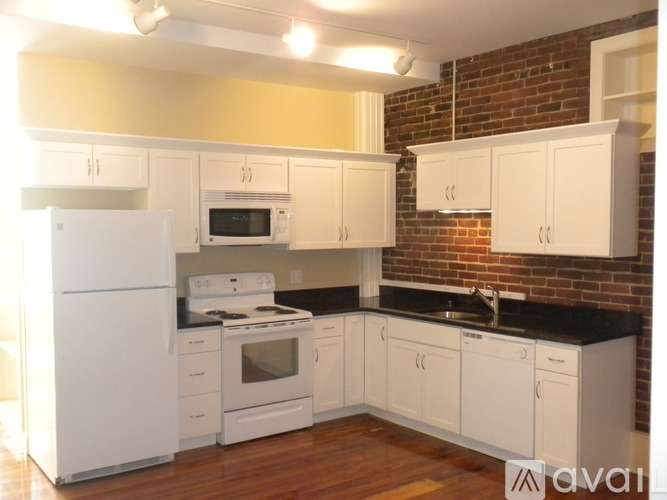A kitchen with white appliances and cabinets.