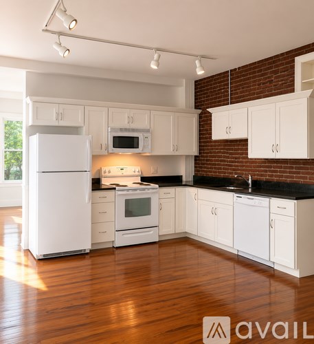 A kitchen with white appliances and cabinets.