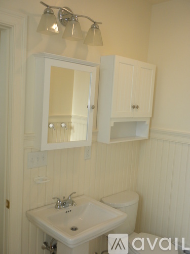 A bathroom with a sink, mirror, and toilet.