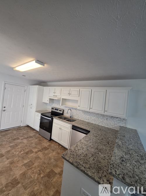 A kitchen with granite countertops and white cabinets.
