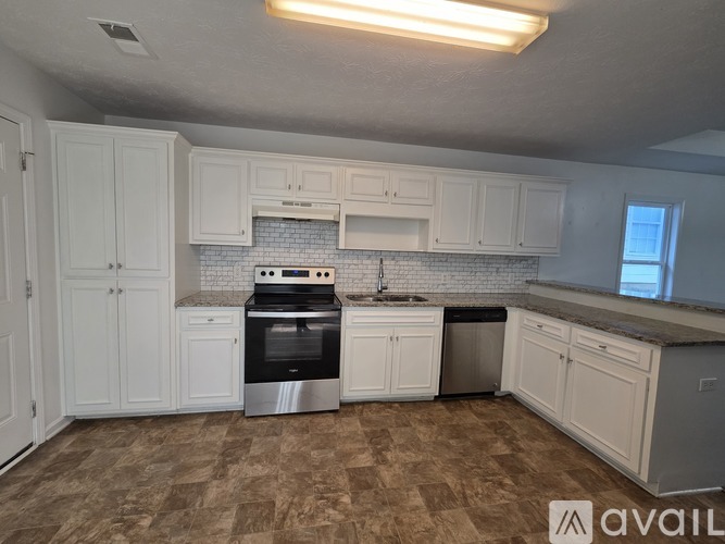 A kitchen with white cabinets and a tiled backsplash.