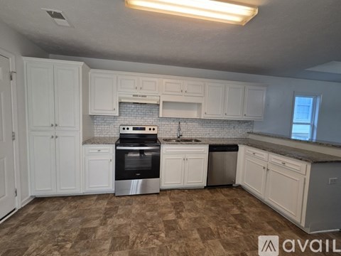 A kitchen with white cabinets and a tiled backsplash.