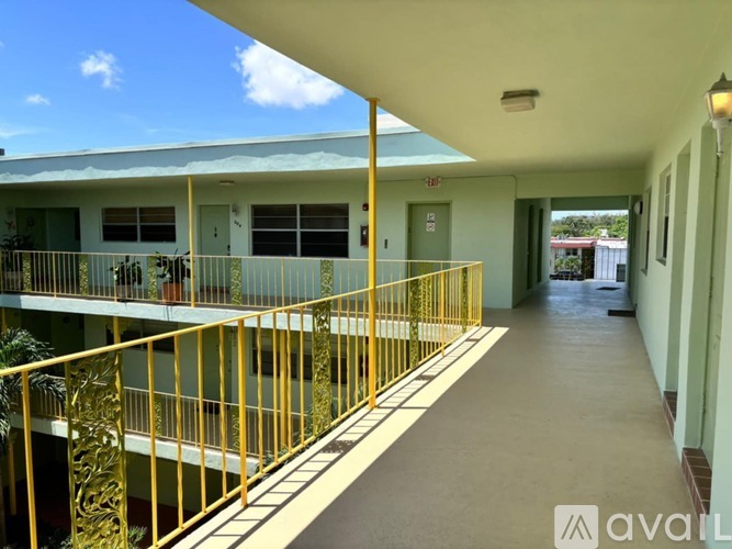 A yellow railing on a balcony with a view of the sky.