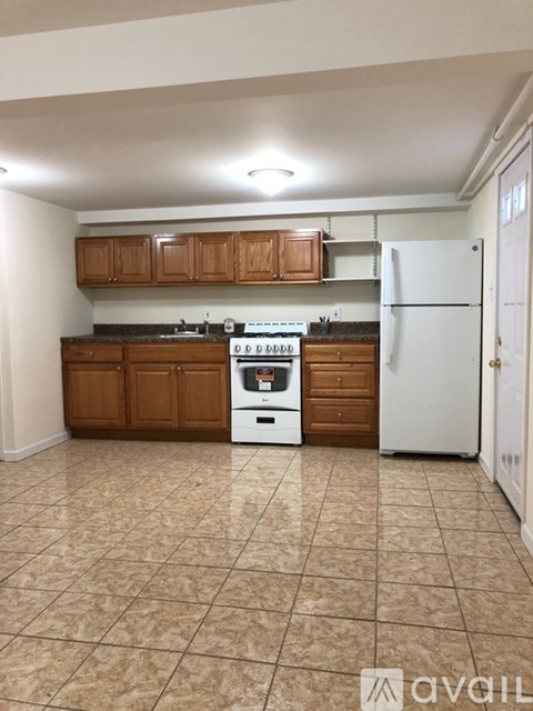 A kitchen with brown cabinets and a white fridge.