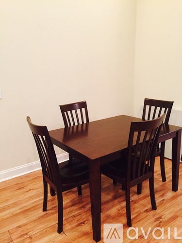 A brown wooden dining table with four chairs.