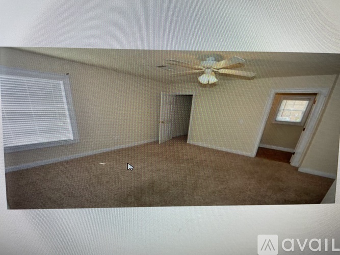 A room with a ceiling fan and a window with blinds.