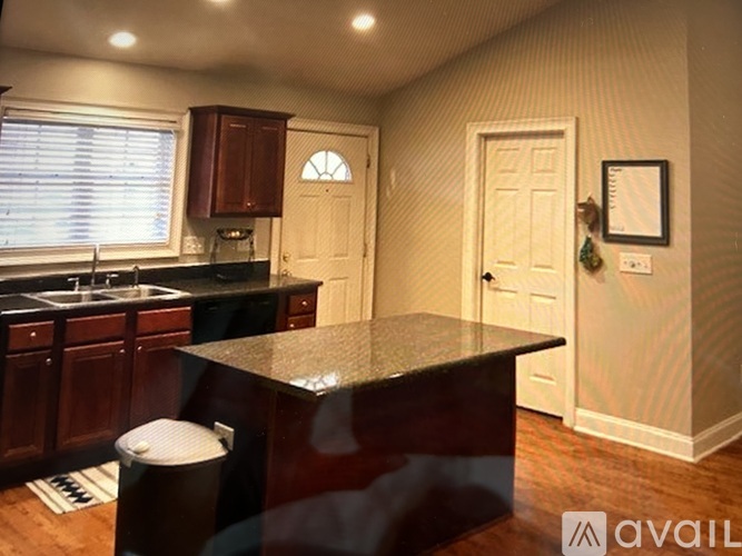 A kitchen with a black counter top and wooden cabinets.