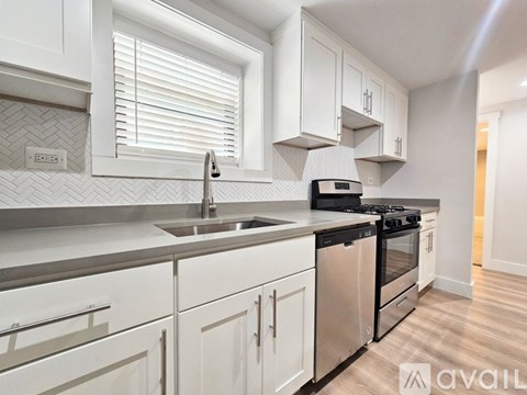 A modern kitchen with white cabinets and stainless steel appliances.