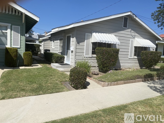 A house with a white awning and a small front yard.