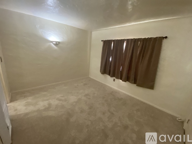 A room with a brown curtain and a light on the ceiling.