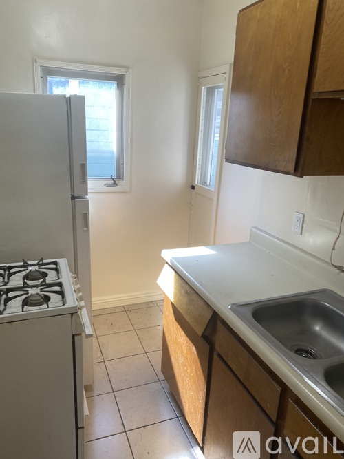 A kitchen with a stove, sink and cabinets.