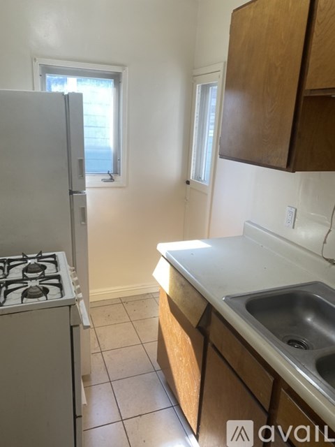 A kitchen with a stove, sink and cabinets.