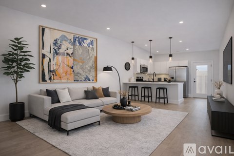 A modern living room with a large painting on the wall and a grey sofa.