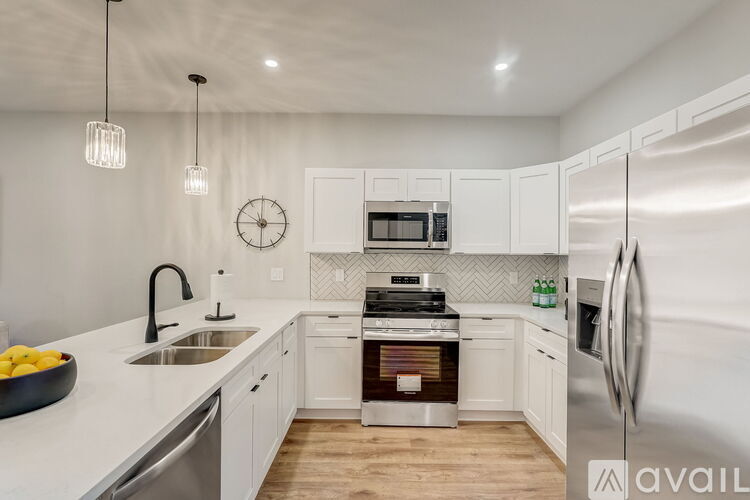 A modern kitchen with white cabinets and stainless steel appliances.