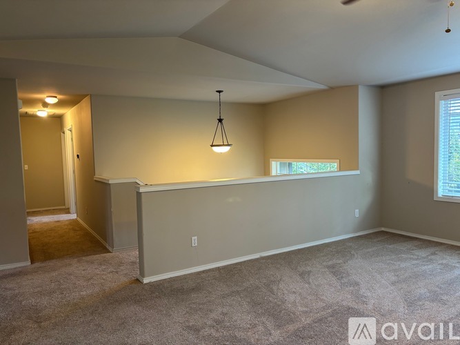 A room with a carpeted floor and a window with blinds.