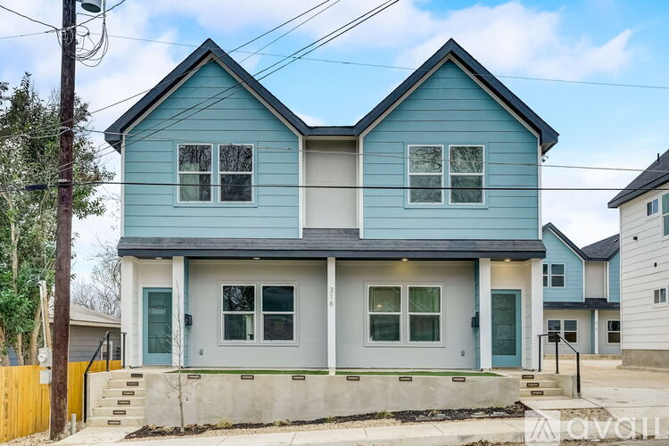 A blue house with white trim and a grey roof.