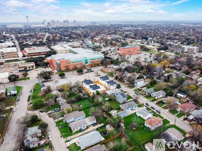 A bird's eye view of a residential area with houses and a large building in the background.