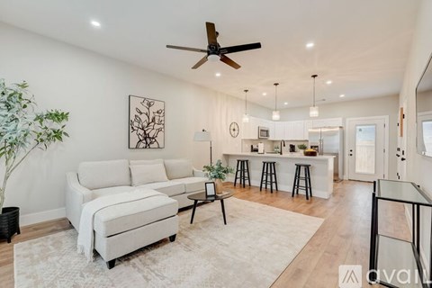 A living room with a white couch and a ceiling fan.