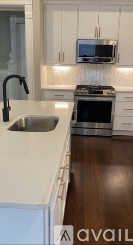A kitchen with white cabinets and a black stove top.