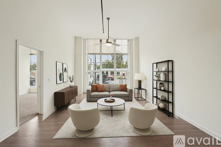 A living room with a large window, a sofa, a chair, and a coffee table.