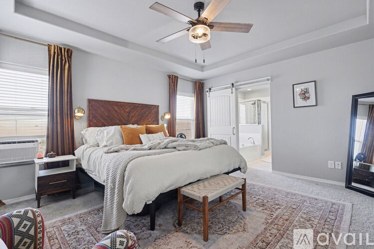 A bedroom with a large bed and a ceiling fan.