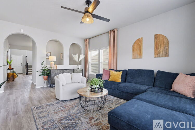 A living room with a blue couch and a white chair.