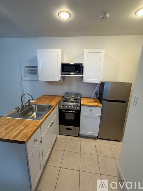 A kitchen with a sink, stove, and refrigerator.