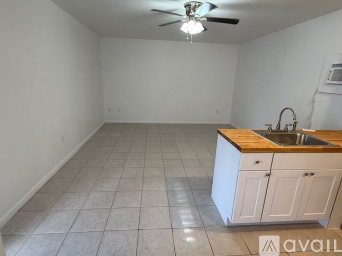 A kitchen with white cabinets and a wooden countertop.