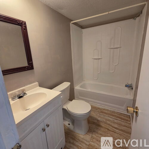 A bathroom with a toilet, sink, and bathtub.